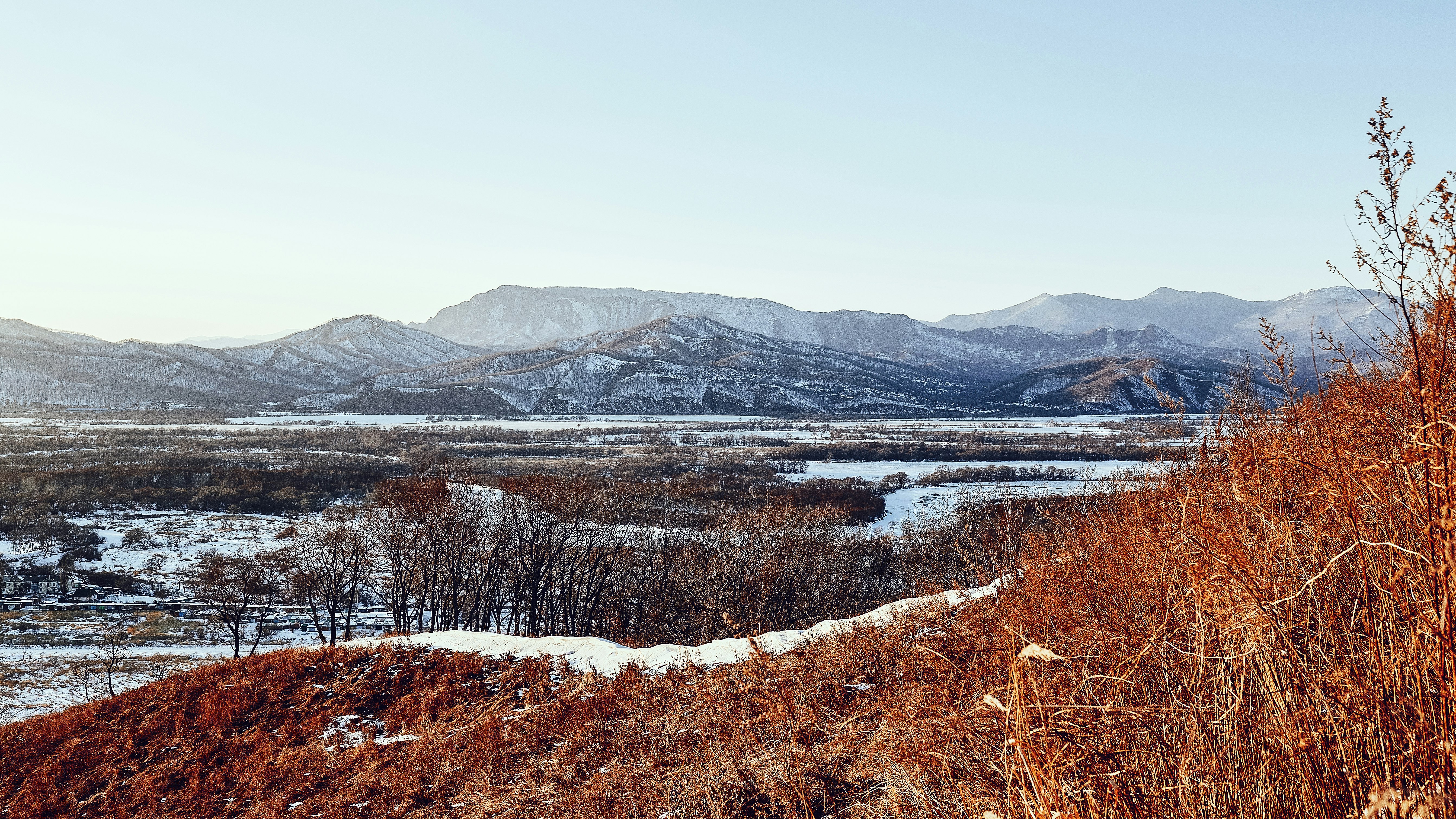 snow covered mountain near lake during daytime